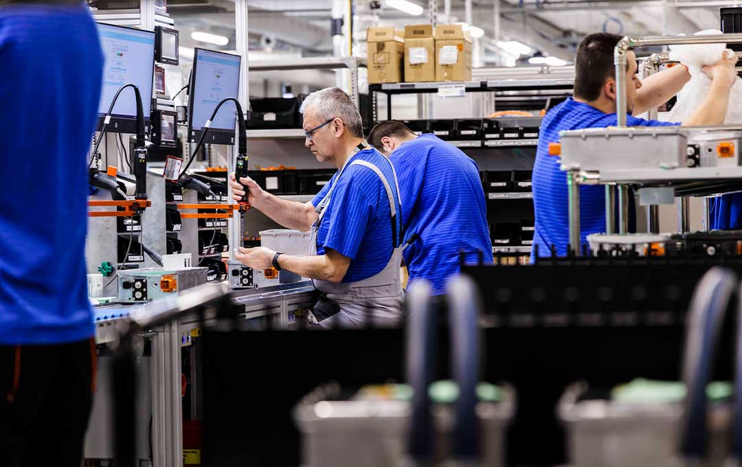 Bel associates working on an assembly line