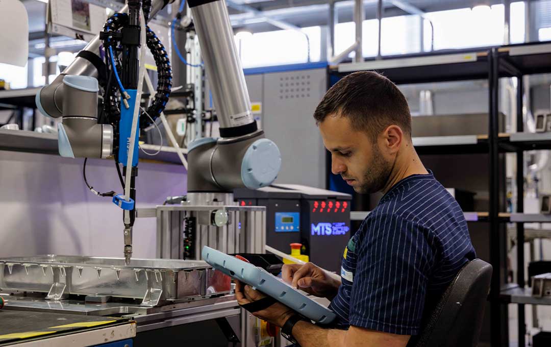 Image of a person controlling a machine with a tablet.