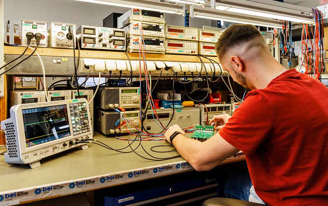 Electrical engineer at workbench testing electronic components