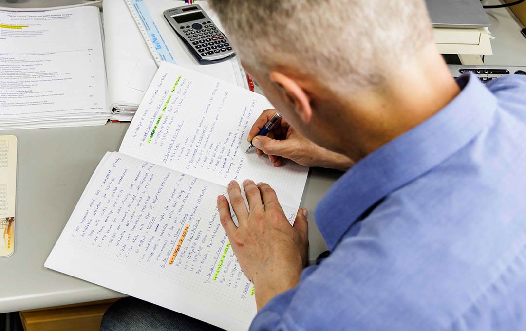 Engineer hand-writing notes about power application for Melcher product development